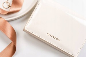 Portfel Peterson w białym kolorze zamknięty na zatrzask, wyposażony w suwak do zamykania kieszeni na monety.