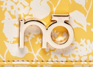 Żółta listonoszka Nobo – detal złotego zapięcia i logo marki na klapce